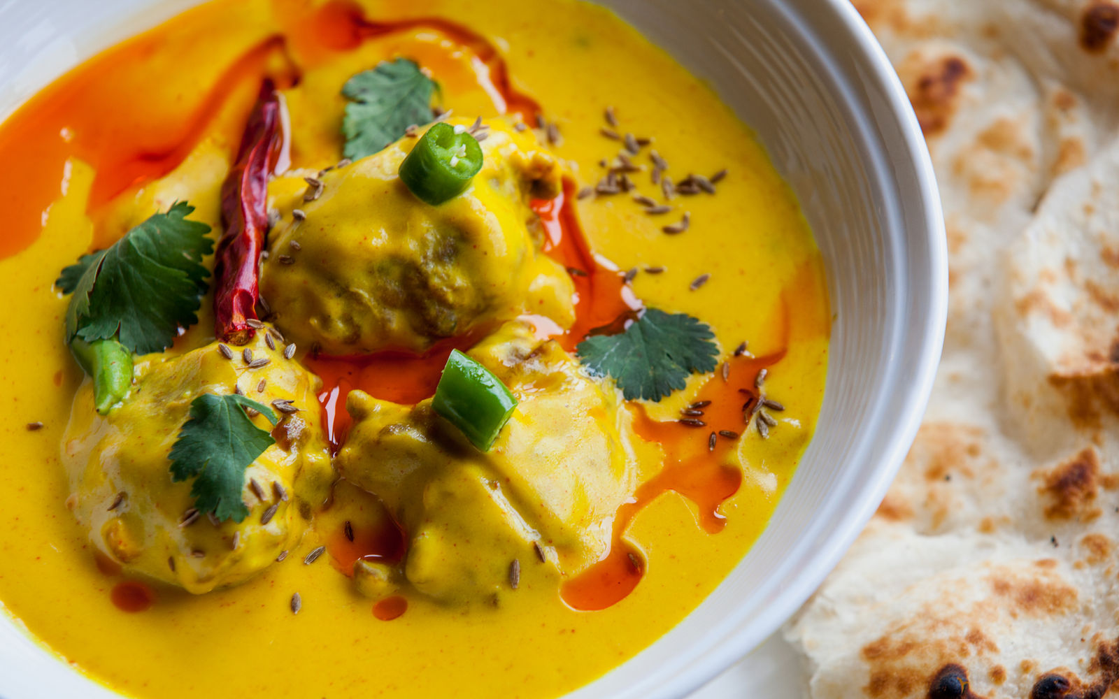 Golden Indian curry with chilli, coriander and naan